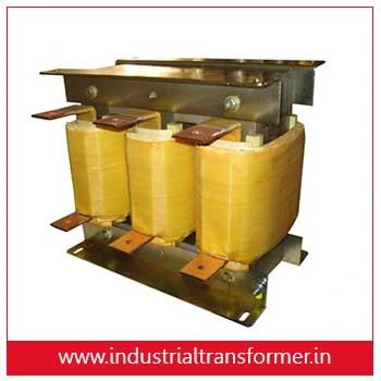 Three‑phase power transformer with yellow insulated coils mounted on a metal frame.